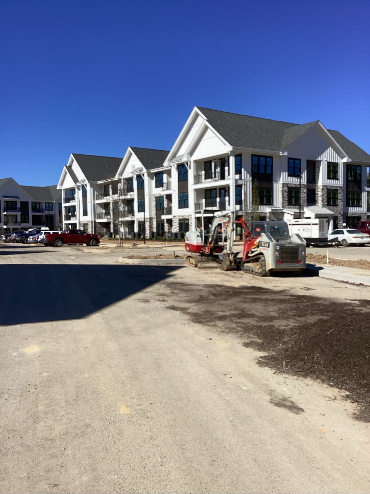 Multi-family apartment buildings with exterior finishes nearing completion, street view
