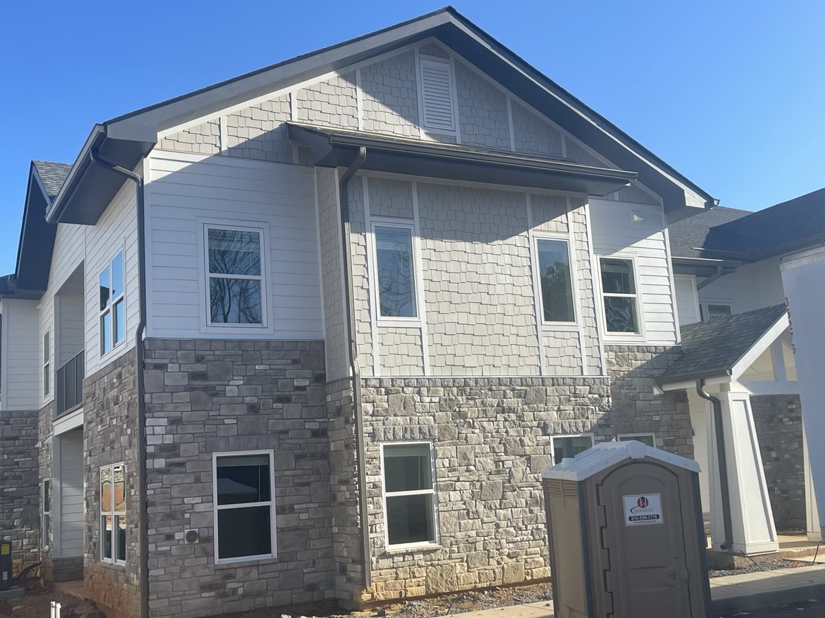 Row of completed multi-family residential buildings with finished exteriors