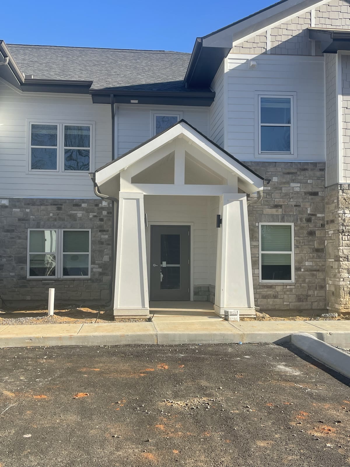 Completed townhome building with craftsman porch entry and stone veneer